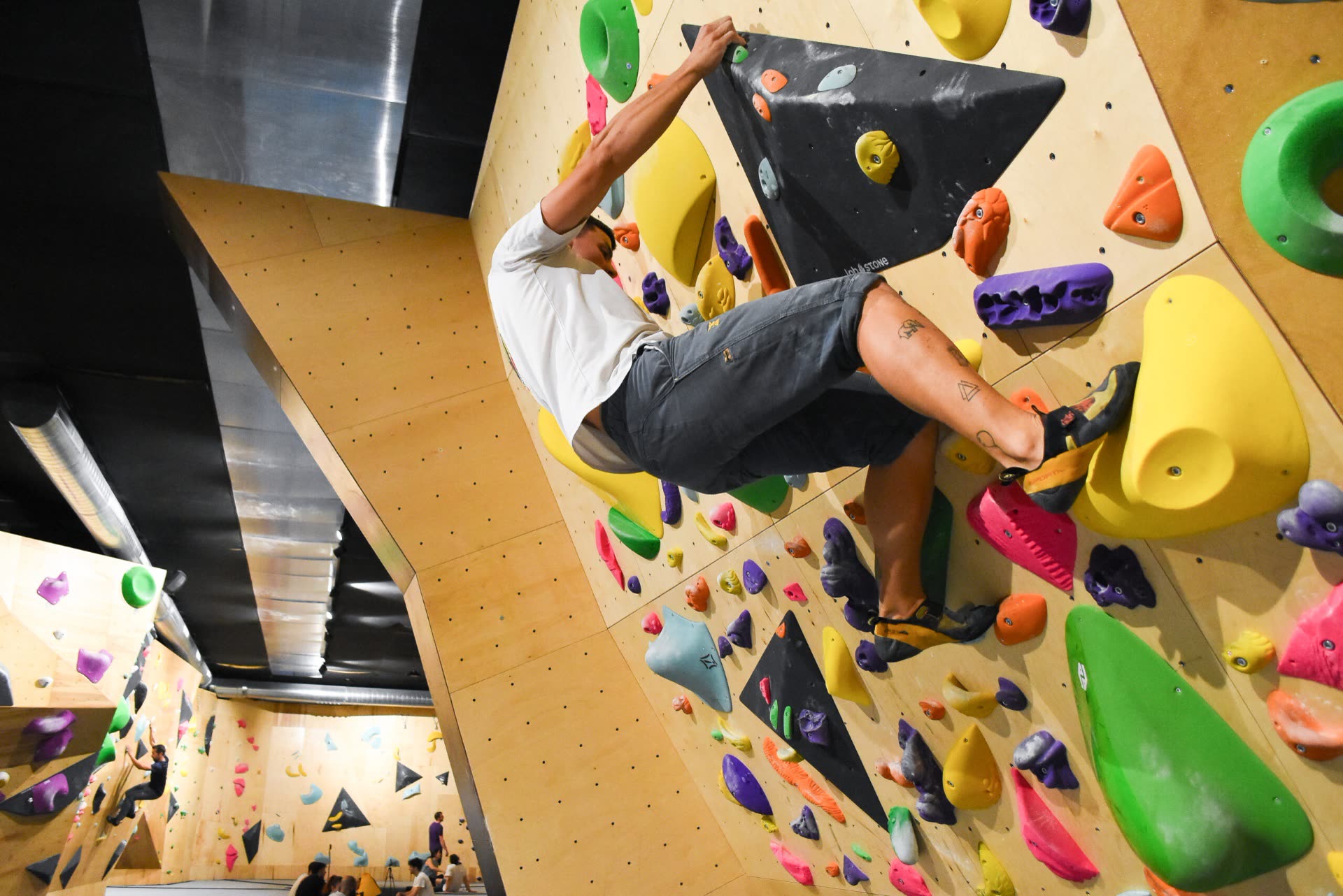 Escalador superando un desplome en el rocódromo de Neko Escalada, en Logroño
